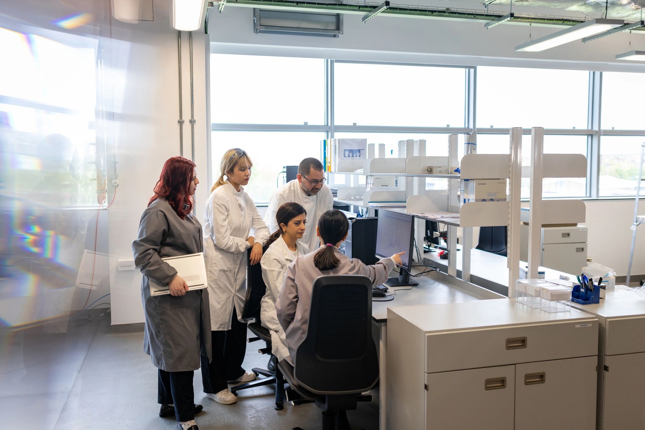 Students gathered around a computer in a lab